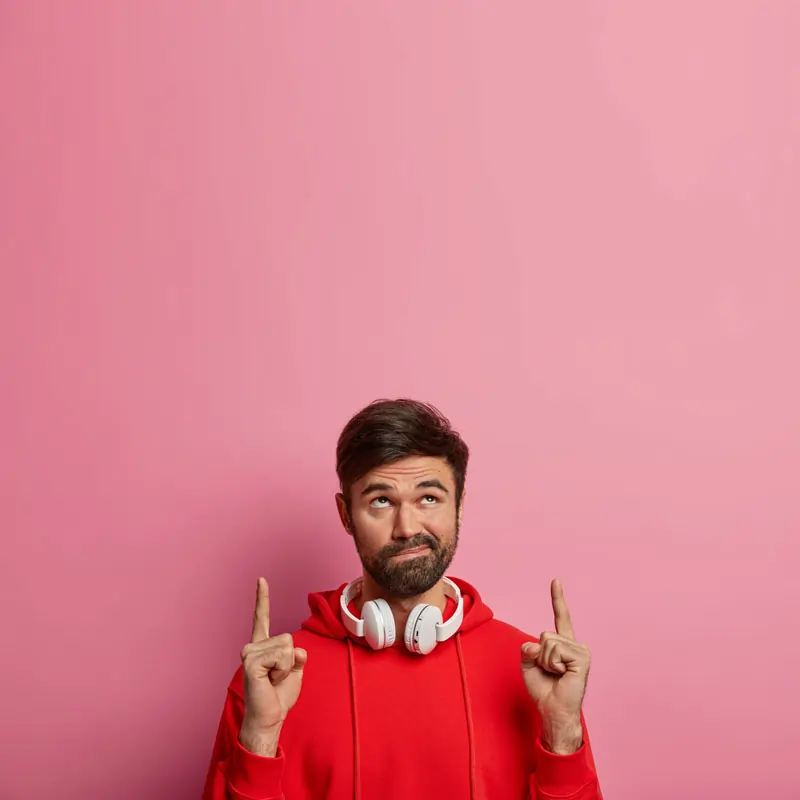 Ein Mann in rotem Hoodie zeigt nach oben, um Vorschläge für Artikelwünsche zu unterstützen.