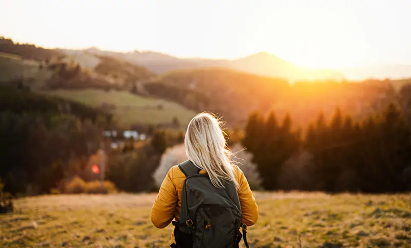 Person wandert in der Natur bei Sonnenuntergang – Symbol für Loslassen und Neuanfang nach einer Trennung.